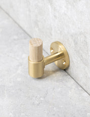 SIGNATURE hook in Brushed Brass/Oak. Luxury hardware made of solid brass by BRANDT Collective.