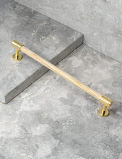 REFINED END pull bar 186 mm in Polished Brass/Oak. Modern cabinet hardware made of solid brass by BRANDT Collective.