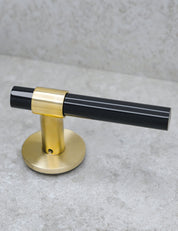 SIGNATURE door handle in Brushed Brass/Black Horn. Modern door hardware made of solid brass by BRANDT Collective.